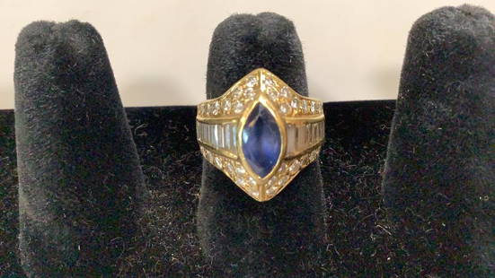 18 K Diamond Ring: marquise cut sapphire(possibly) is surrounded with Diamonds in a 18 k yellow gold mount, 44 round brilliant and baguette diamonds, estimated total weight .095ct