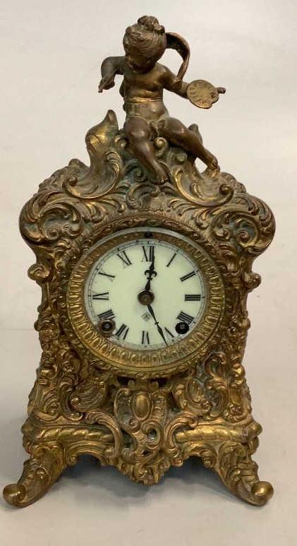 Ansonia Ornate Mantle Clock: 13 inches tall , with ornate body scroll work in the French style, with a Puti finial representing the Arts…porcelain face with beveled glass door …works marked interior for Ansonia * no k