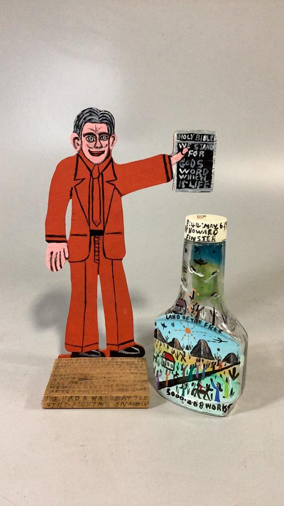 2 Pieces Outsider Visionary Art, Howard Finster: 13 inch painted wooden figure of man holding a Bible, with scripted story at base, 8.5 inch salad dressing bottle, painted with Land of the Free, 1986, on reverse is cabin, field, ( Rev. Finster 1916-