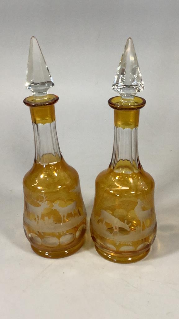 Pair Bohemian Amber Etched Decanters: 14 inches tall, stag and deer in a woodland setting panel cut stoppers