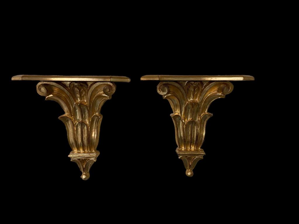 Pair Neoclassical Italian Gilt Wood Wall Brackets: Acanthus leaf motif wall brackets by Decorative Crafts, Inc. Stamped Made in Italy on back. Surface scratches to shelves on both. Minor imperfections. 15H x 13W.