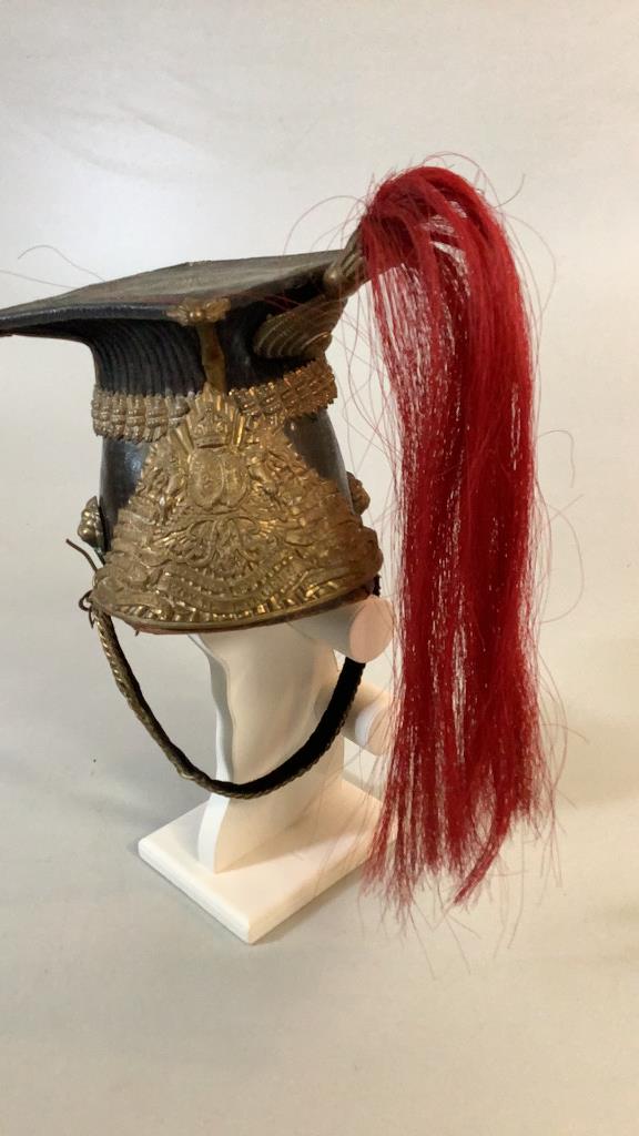 Royal Lancers Helmet: British 19th Century , leather body with helmet plate described with battles including South Africa 1899, 6.5 inch flat crested top, button with crown and flag, also 9, braid work chin strap, claret h