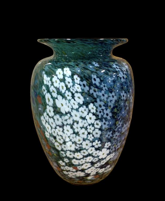 A Signed Peter Raos Art Glass Vase, 1998: 7.5 inch tall vase from the Monet Spring Garden collection. Swaths of red, blue, lavender, and white floral canes set against a mottled black & green field. Hand inscribed near base, Raos 1998 New Zea