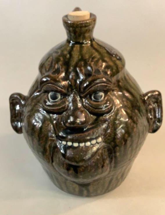 Clete Meaders Pottery Face Jug: Dark runny alkaline glaze, 9.5 inch jug with comical facial features inscription on bottom and dated 2002