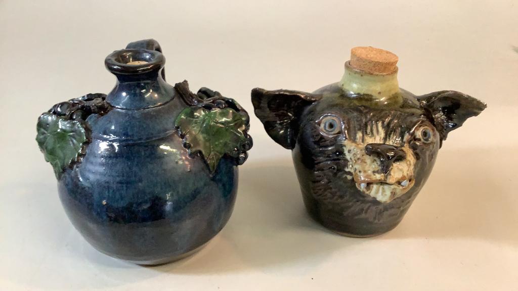 2 Pottery Jugs: Blue Glazed 7.5 inch jug with grape and vine decoration by Bobby Ferguson, GA, 7 inch dog face jug with ears, loop handle, stamped but not determined