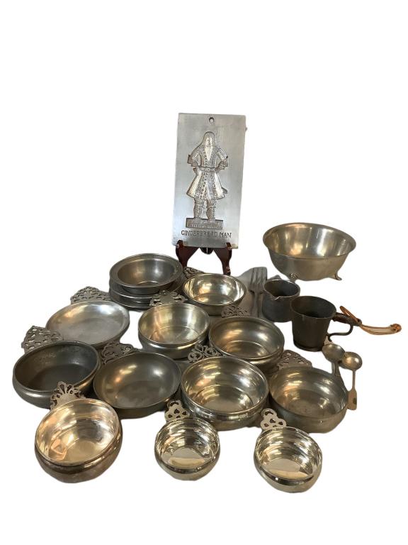 19 PiecesPewter: Includes 11 Porringers varied sizes, Colonial Williamsburg Gingerbread man mold, Steiff footed bowl, fork,Wenn 6 inch bowl, early cup, measure with pour spout