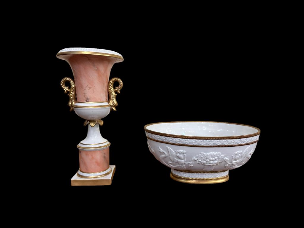 Mottahedeh Porcelain urn and Center Bowl: 10.5 inch urn with salmon marbling, gilt details and dolphin handles, sticker residue..9.5 inch bisque porcelain center bowl, neoclassical motif, gilt details, adhesive gum to interior of bowl