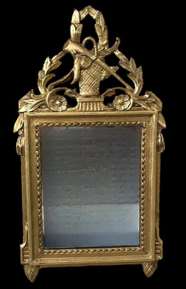 French Louis XVI Carved Giltwood Mirror: 19th Century, basket crest with game bird and rifle topped with Laurel wreath, scrolling foliates, beaded trim, pinecone drop finials..clouded mirror with some loss, repairs to crest, 26H x 14W x 1.5D