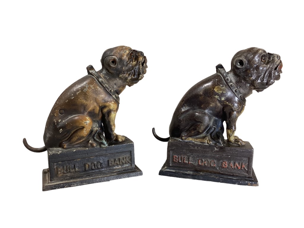 2- Cast Iron Bull Dog Banks: This clever pup is made to balance coin on his nose and when tail is depressed he swallows the coin. Both with glass eyes, one stamped with pat. Date of 1880. Remnants of old paint. Originally produce
