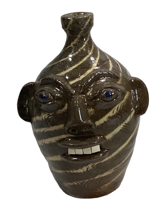 Walter Fleming Swirl Face Jug: 10 inch swirl face jug, porcelain teeth, bug eyes, loop handle, signed at base Line Item # 17