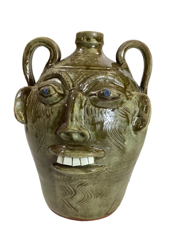 Walter Fleming Double Face Jug: Folk Pottery Jug, 12 inch’s tall with double face, porcelain chip teeth, bug eyes, blue runs to handles* tiny glaze chip to one ear Line Item # 12
