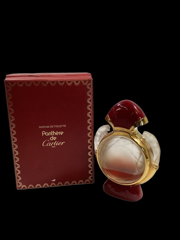 Panthere de Cartier Parfume: 6.6 oz Toilette Splash Bottle. Facet cut round bottle with opposing Panthers, gold banded bottle. In original box. Some content remains, used or evaporated. Staining to interior box Line Item # 31