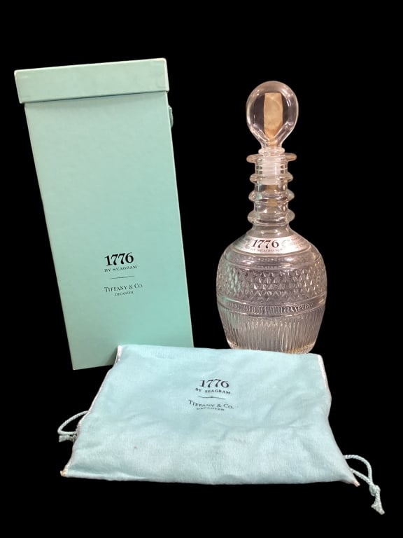 Tiffany and Company Decanter: Seagram 1776 decanter designed by Tiffany and Company. 11 inch tall distinctive bottle with original banded label, tax sticker, felted carring bag and signature Tiffany blue box Line Item # 281