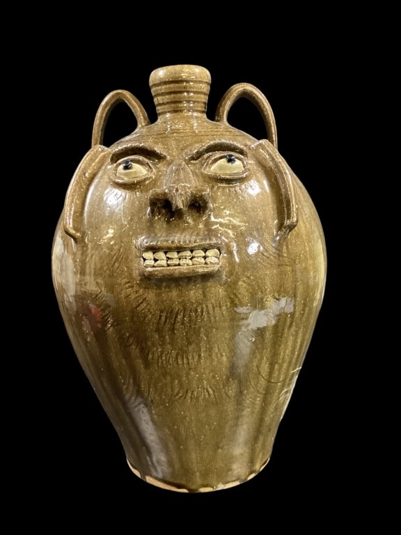 Steve Abee Face Jug: Olive tone alkaline glazed stoneware jug, double row clay teeth, blue eyes, incised lines for eye lashes and beard, well defined nose, stamped SEA upper shoulder? large 20 inches tall