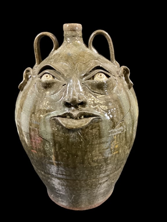 Kim Ellington Stoneware Face Jug: Large 20 inch tall face jug, well defined mouth, small chip teeth,, strap handles. Signed GKE, Green glossy glaze with drip runs* firing crack base ( not thru )