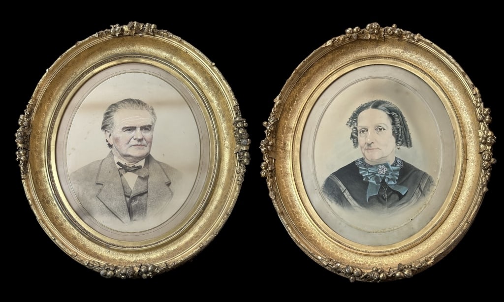 Pair of Watercolor Ancestral Portraits: Mid to late 19th century, watercolor portraits of a stoic man and woman on paper with gouache accents, glazed and housed in exquisite gilt gesso frames decorated with pomegranates and berries, faux bo