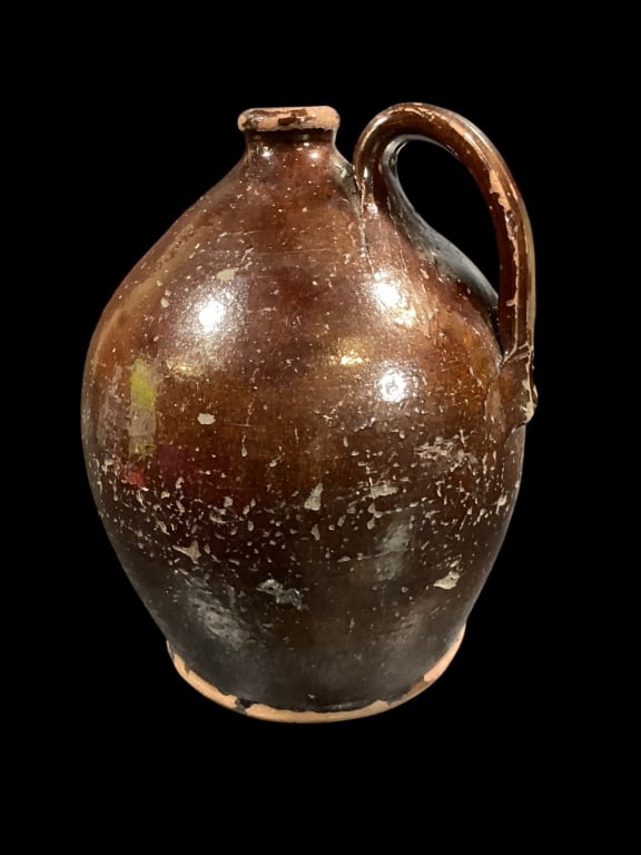 Ovoid Fluid Jug: Dark brown glassy glaze applied strap handle, with thumb notched strap, heavy clay, shaped spout