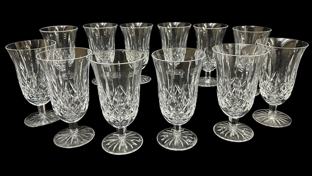 Twelve Waterford Lismore Iced Tea Glasses: 6.5 inch cut crystal stems with vertical cuts over a cross hatch design below, faceted stem over cut circular base with starburst design, acid etched Waterford mark..light surface grimes, 1 with chipp