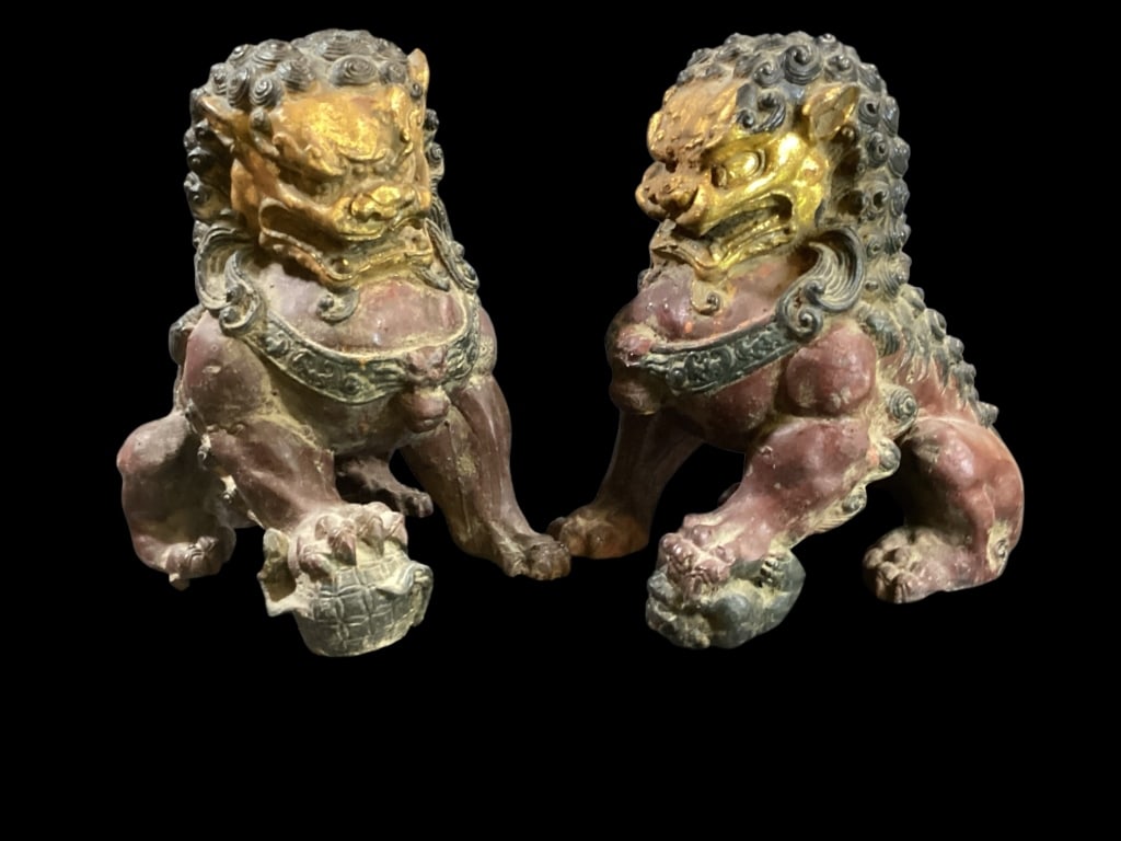 Pair Chinese Guardian Lions: Cast Iron with polychrome paint, in iron red with black and gilt accents. Male and Female forms, hehe rests his foot on ball , she with her cub, representing protection and good fortune. 11 high x 9.5