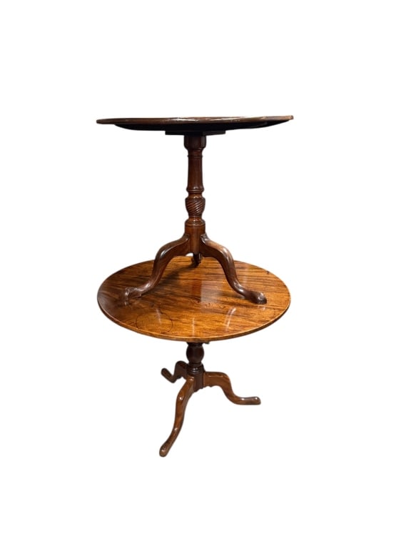 British Early 19th C Tilt-Top Tables: Two of British early 19th-century tilt-top tables with wooden tripod bases. Features circular tops with rich wood grain detailing and visible surface wear consistent with age. Includes tilt-top mechan