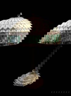Slag Glass Table Lamp: In style of Tiffany, with banded slag mushroom shade. Art Nouveau styled base with reeded column, geometric and foliate designs. 25 inches tall, leaded panels on shade in oyster shell, green, deep lav
