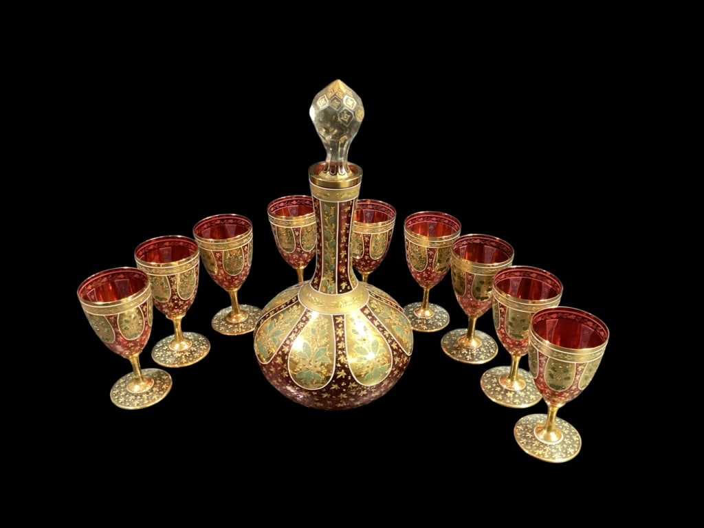 Bohemian Decanter Set and Cruets: Beautiful gold enameled design on ruby glass. Characteristic of Moser, the set includes a 12 inch tall decanter with slim neck and facet cut stopper, set of 9 wine goblets @ 4 3/4 inches, and a pair o