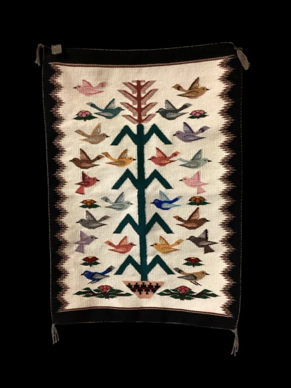 Navajo Tree of Life Rug: Intricate woven rug with center cornstalk, symobolic of the connection between Dine? people and the Universe. Birds represent messengers to the gods. Cream center ground, black border, 4 corner tassel