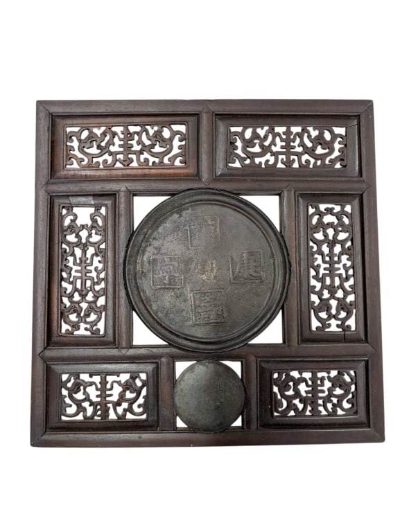 Two Carved Wooden Panels with Metal Detail: Two intricately carved wooden panels. One panel features decorative carvings, and another includes two possibly bronze antique mirrors, center and perforated ornamentation, measuring 14.25 inches squa