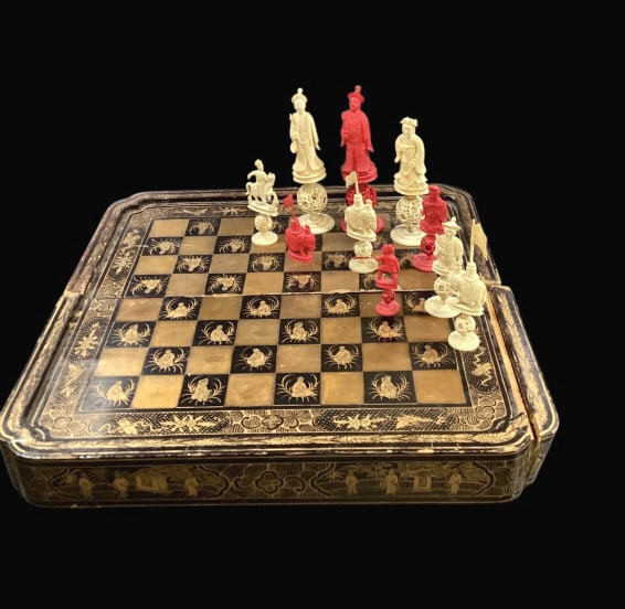 Antique Black Lacquered Game Board: 19th century Chinese Export black lacquer game board/ box. Beautifully painted in black and gold with seated figures in the squares. The border showing court scenes, and foliage. Folding board convert