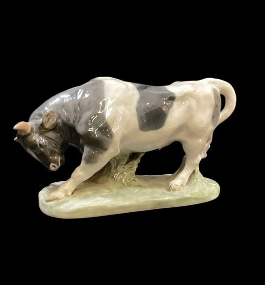 Royal Copenhagen Porcelain Figural: Model number 1195, Known as Bull digging Ground. Designed by Artist Knudsen Kyhn, 14 inches long, hand painted with glazed body. Base bears Copenhagen mark,repaired horn