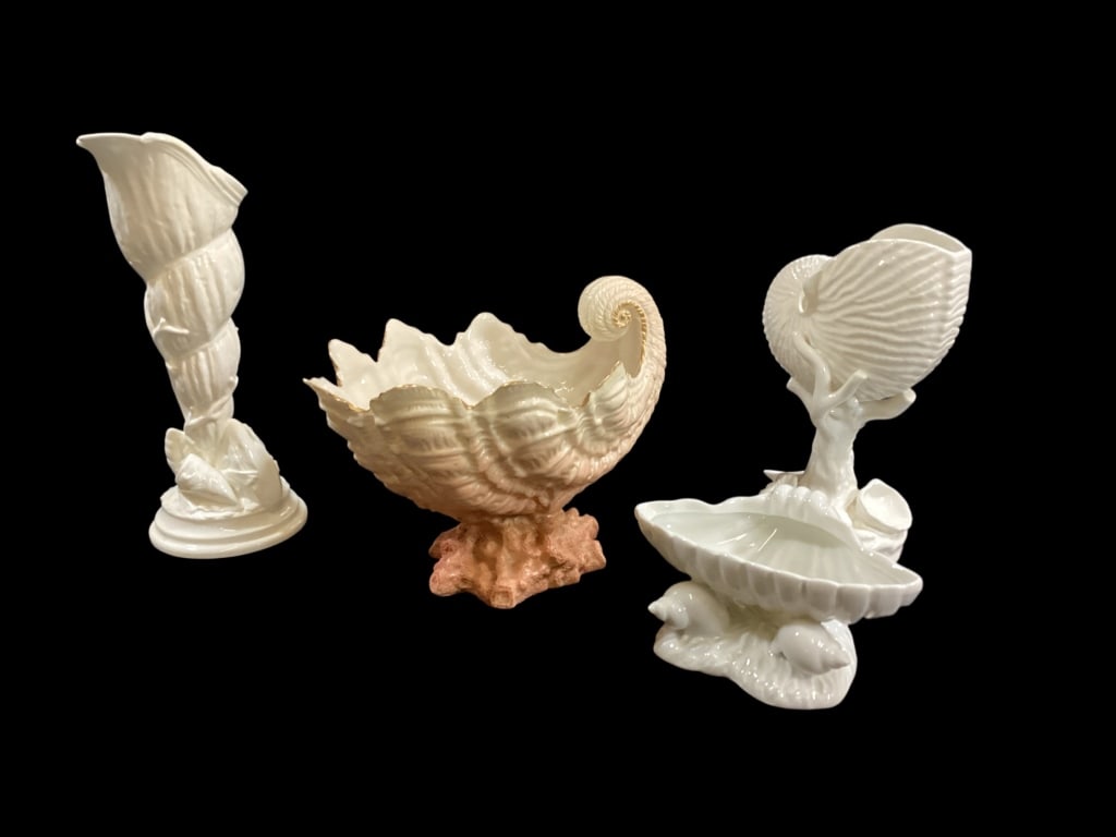 Porcelain Table Objects: Two Royal Worcester sea shell vases, 9 inch and 7 inches with a nautilus, in bisque ivory. Royal Ivory, Stoke on Trent, Nautilus shell footed bowl. Shaded pink coral form base. Shell form sweetmeat di