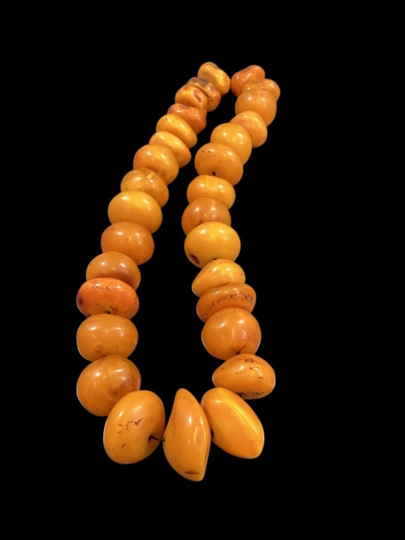 African Amber Trade Beads: Huge strand simulated amber trade stone beads, 32 inches in length. Termed African Amber they were created of early phenolic resin to simulate amber, and were used by Europeans to trade for more valua