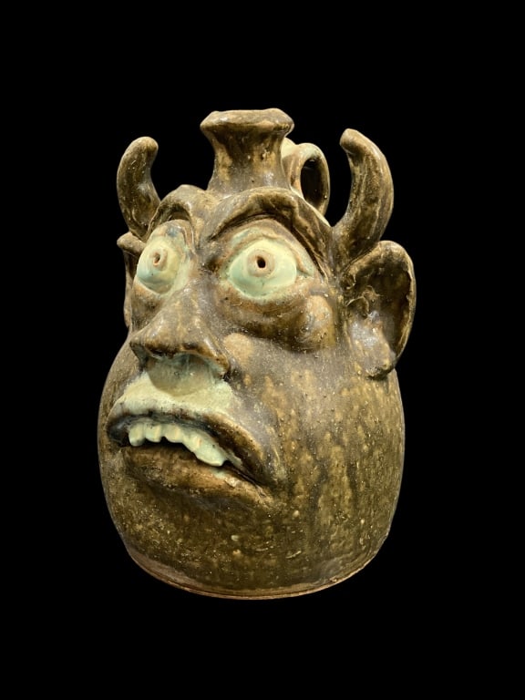 WA Flowers Pottery Devil Jug: North Carolina folk Art pottery by artist, WA Flowers 12 inches tall tall ugly Face Devil Jug. Alkaline Glazed stoneware, featuring wide bug eyes, big nose, open mouth with teeth, and prominent horns.