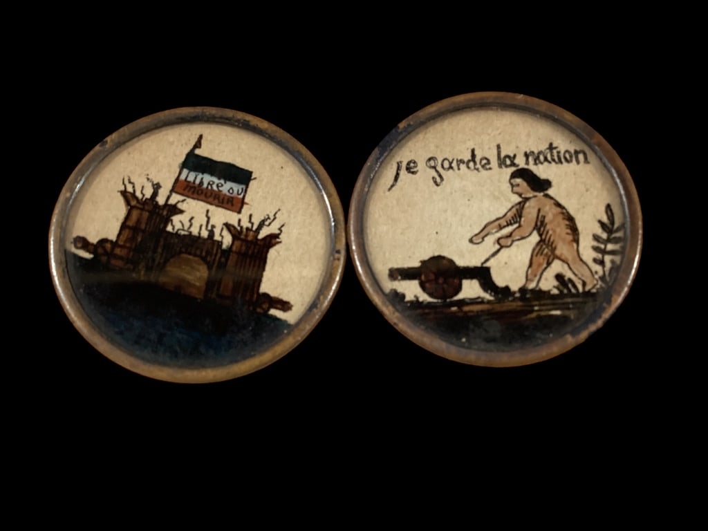 Two Early Hand Painted Buttons: French, painted on porcelain 1.5 inch diameter buttons, French Revolution depicting a man firing a cannon, and a fortress with French Flag for liberty