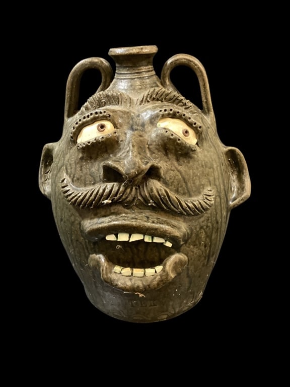 Tony King Stoneware Face Jug: Large 15 inch tall face jug by Tony King Seagrove NC. Runny alkaline glazed with open mouth, double row teeth, side glancing eyes. Mustache, and busy brows. Stamped TLK. Reverse with double snake and