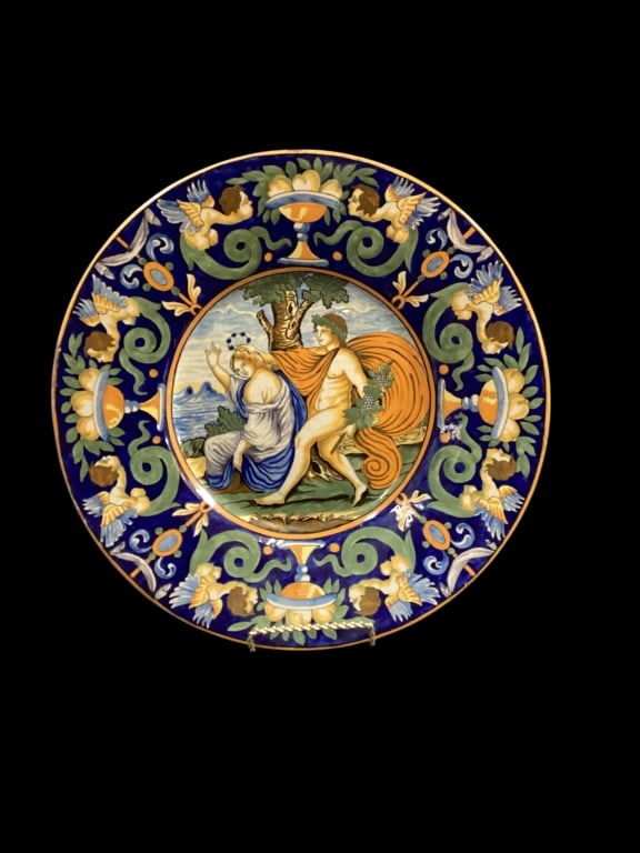 Italian Majolica Charger: Painted with a Istoriato scene, vibrant colors hand decorated enamels. 13.5 inches. Wide border with puti and fruit. * rim chip