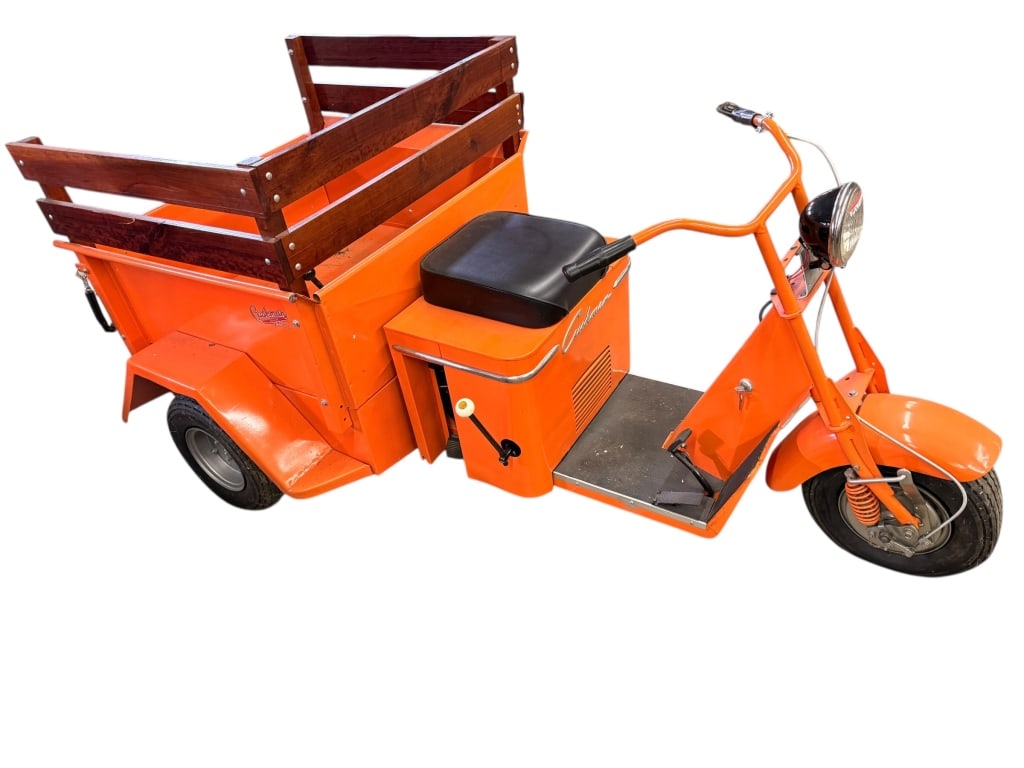 1954 Cushman Truckster: 1954 Cushman Truckster Model 780 is a beautifully restored three-wheeled utility vehicle finished in a vibrant orange with a custom wood stake bed. A versatile workhorse of the mid-century era, it is