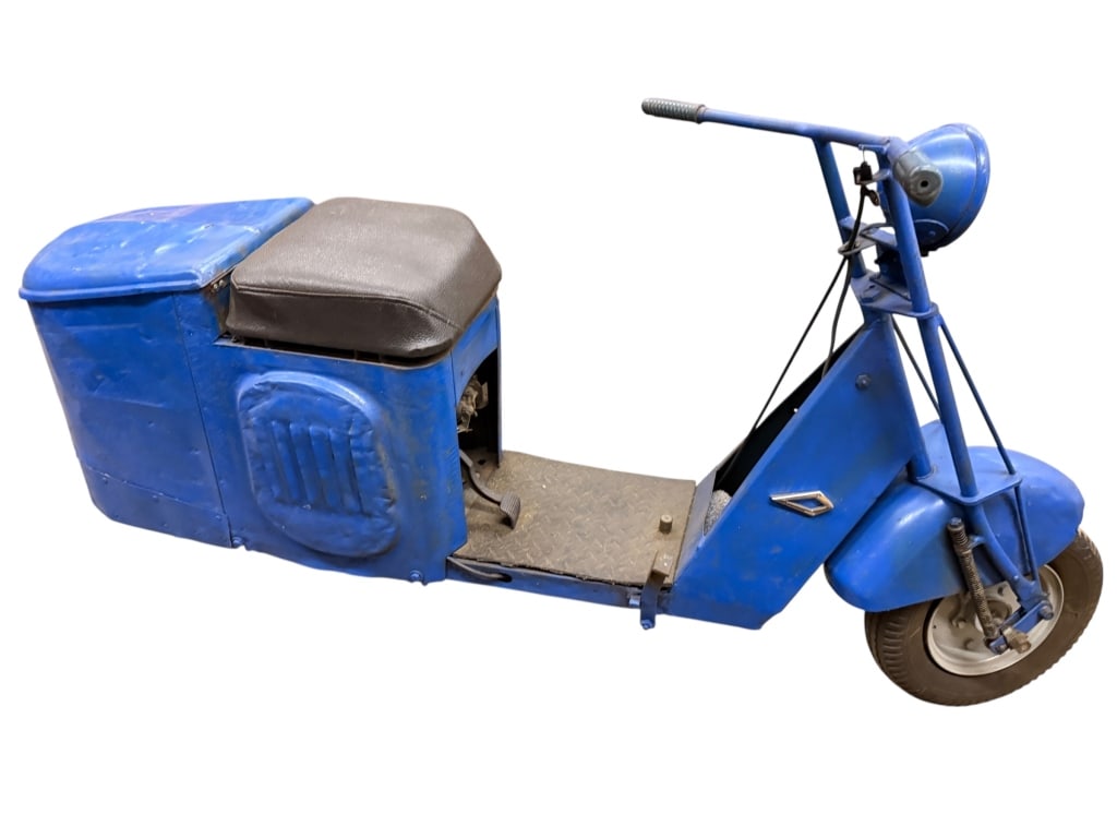 1939 Cushman Scooter: ,1939 Cushman Model 51 is a classic "step-through" utility scooter. It features a prominent rear engine shroud with cooling vents and a padded black solo seat. This pre-war model showcases the early i