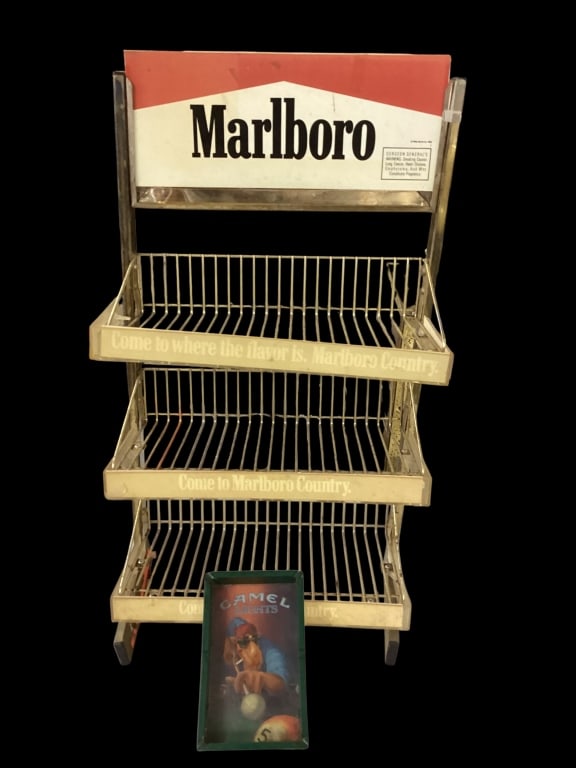 Marlboro Cigarette Rack, Camel Ashtray: Three tiered gold tone retail rack. With cardboard topper for Marlboro Cigarettes, logo fronts ( faded). Joe Camel advertising ashtray, 1992