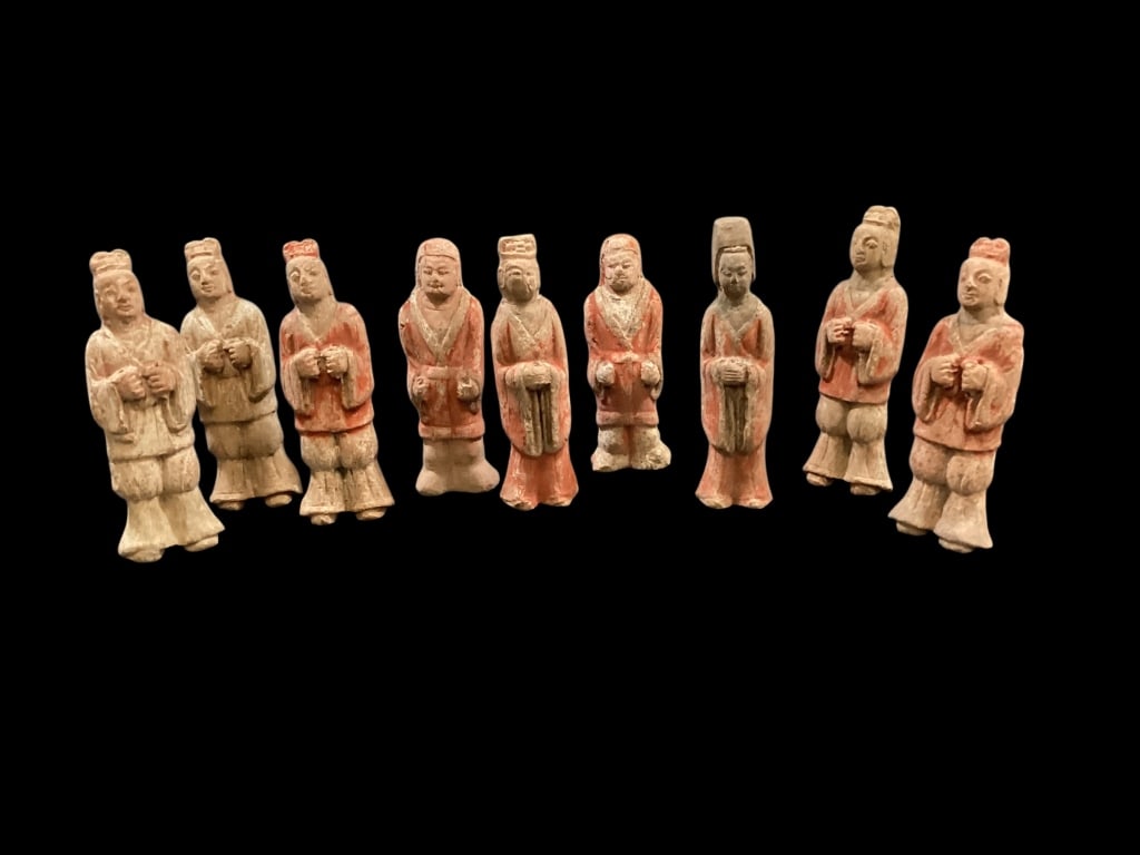 Terracotta Tomb Attendants: Chinese tomb figures, earthenware formed, most 6.5 inches tall, attributed to Sui dynasty. This group of 9 are of one piece with flat or slightly concave backs. Male and female figures, with flowing r