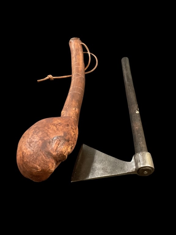 Tomahawk and War Club: Belt axe or throwing tomahawk. Steel axe head mounted on a 14 inch hickory handle. 18 inch war club, curved wood section with attached burl knot, incised line decorative to handle, weighty with