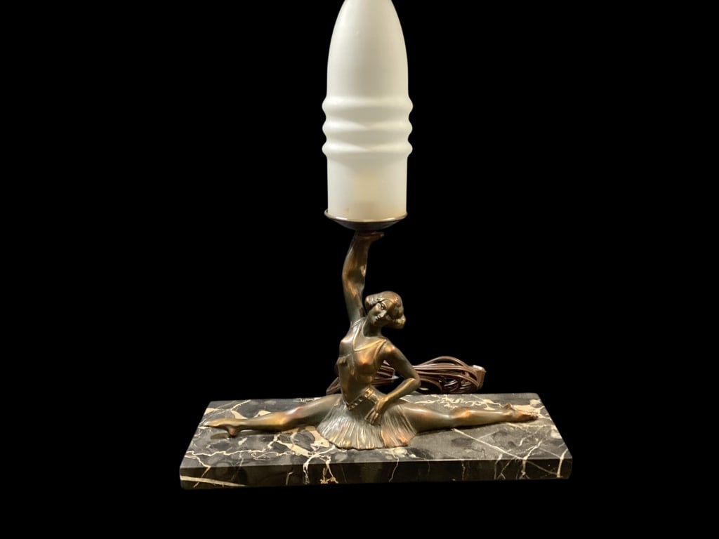 Art Deco Figural Lamp: Bronze sculpture of dancer in split pose, holding a frosted glass shade. Mounted on a black marble base. Frost glass bullet form shade.attribution to Hirsch Company