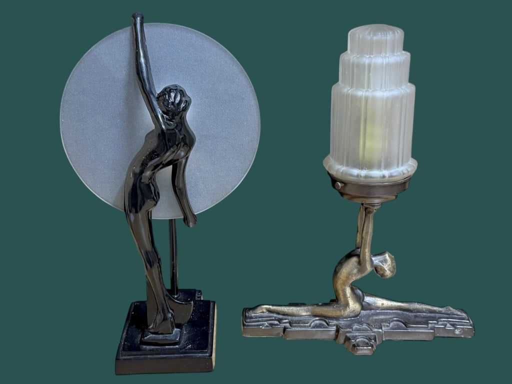 Two Vintage Frankart Style Lamps by Sarsaparilla: 15 inch lamp with Standing nymph holding frosted glass disc shade; 14 inch style lamp of a figure in deep split supporting a skyscraper shade, both are marked Sarsparilla NYC..surface dust, light