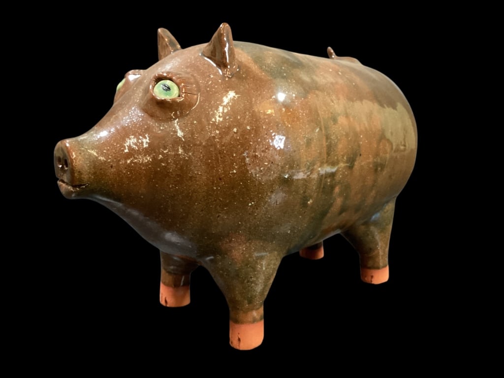 Southern Folk Pottery Piggy: James Roddy Folk Art pottery piggy. 7 x 9 inches. Mottled brown alkaline glazed body, unglazed feet, painted porce