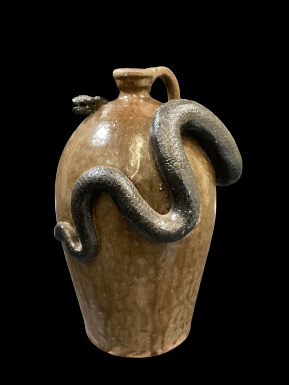Marvin Bailey Folk Art Pottery: Southern folk pottery snake jug, well formed 12 inches tall with jug, brown to green glaze, with coiling black snake surrounding body. Small loop handle, shaped spout. Signed at base