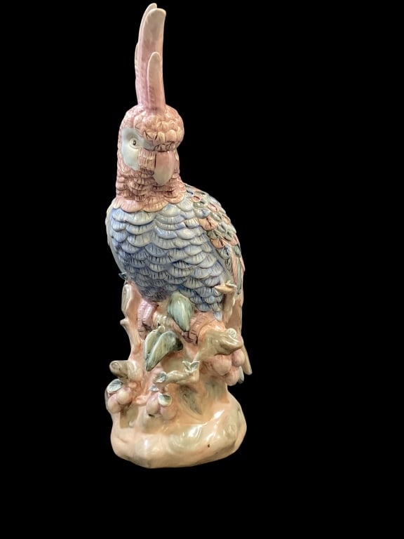 Decorative Porcelain Cockatoo: 17 inch tall seated cockatoo, after style of Karl Ens. Perched on a naturalistic tree beach. Decorated in muted colors of blue, pink and green. Made in Macau. * chip to branch Line Item # 12