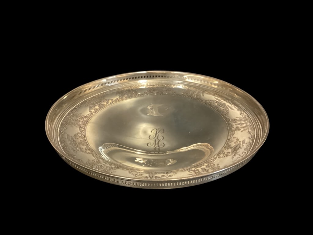 Sterling Silver Footed Bowl: Lovely footed center bowl, 10 inch diameter with intricate urn and floral designed border, reticulated rim, engraved center form. 13.51 ozt approximately.