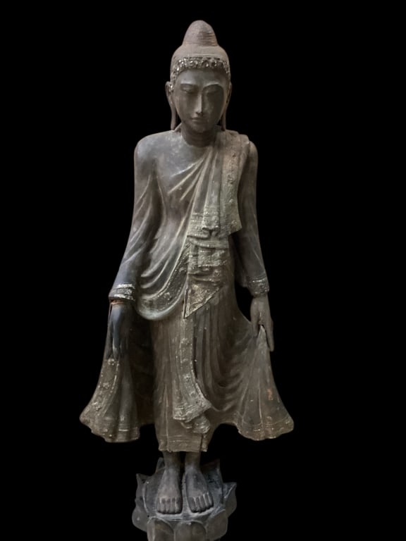 Standing Wooden Buddha: Hand crafted wooden statue,featuring graceful flowing robes, detailed hand gestures representing safety and freedom from fear. In style of Mandalay, isthmus traces of inlay remaining to head