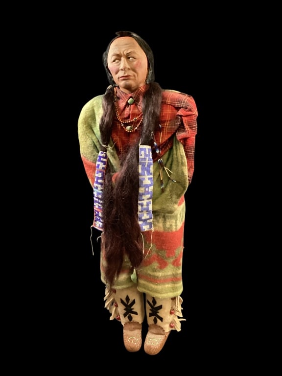 Vintage Native American Skookum Doll: Unusually large Chief Doll, with painted paper mache face, side glancing eyes, black brows, mohair wig. Wrapped body and enclosed arms. Dressed in flannel plaid shirt, blanket wrapped. Felt