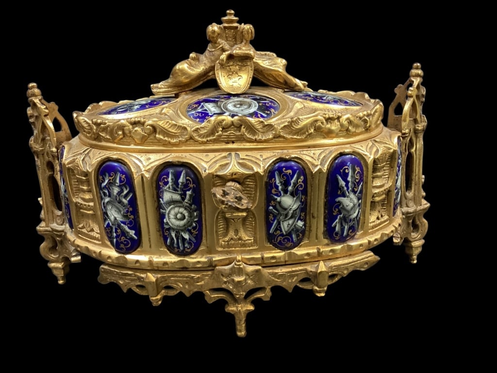 French Revival Casket: Gothic Revival Ormolu box, often associated with with Napoleon III period. Highly ornate, with hand painted porcelain panels inset to lid and body, hinged lig with reclining figures and shield.